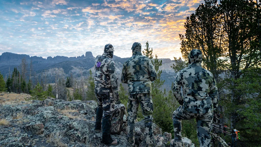 Three elk hunters stand on overlook during a September archery hunt.