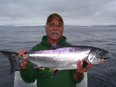 An angler hoists a Chinook salmon caught near Eureka, California. 