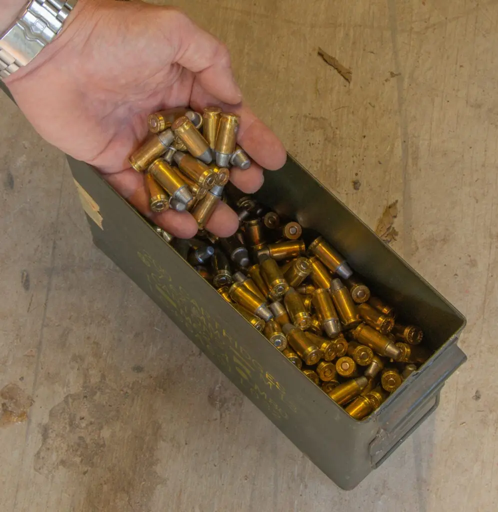 A handfull of ammo being pulled from an ammo can.