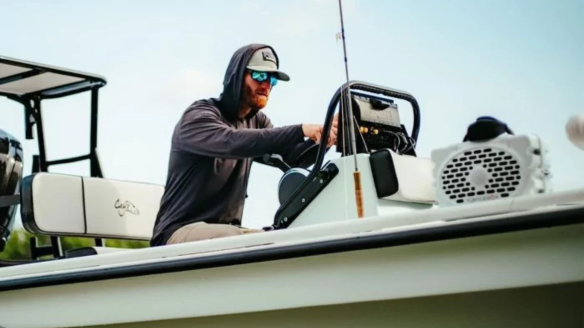 Man driving boat with Turtlebox Gen 2 Speaker