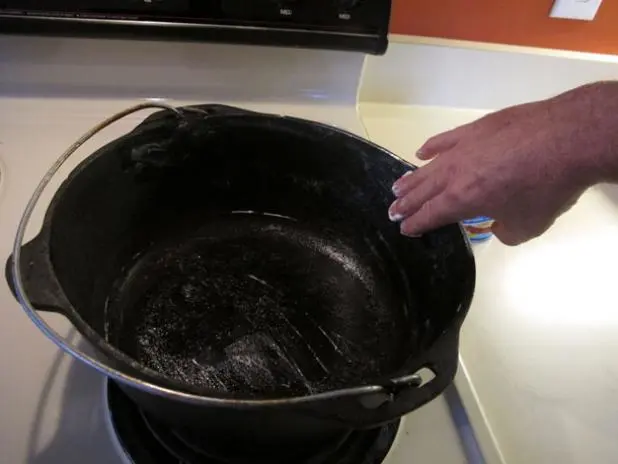 After heating up the pot and letting it cool, add a layer of Crisco to the surface.