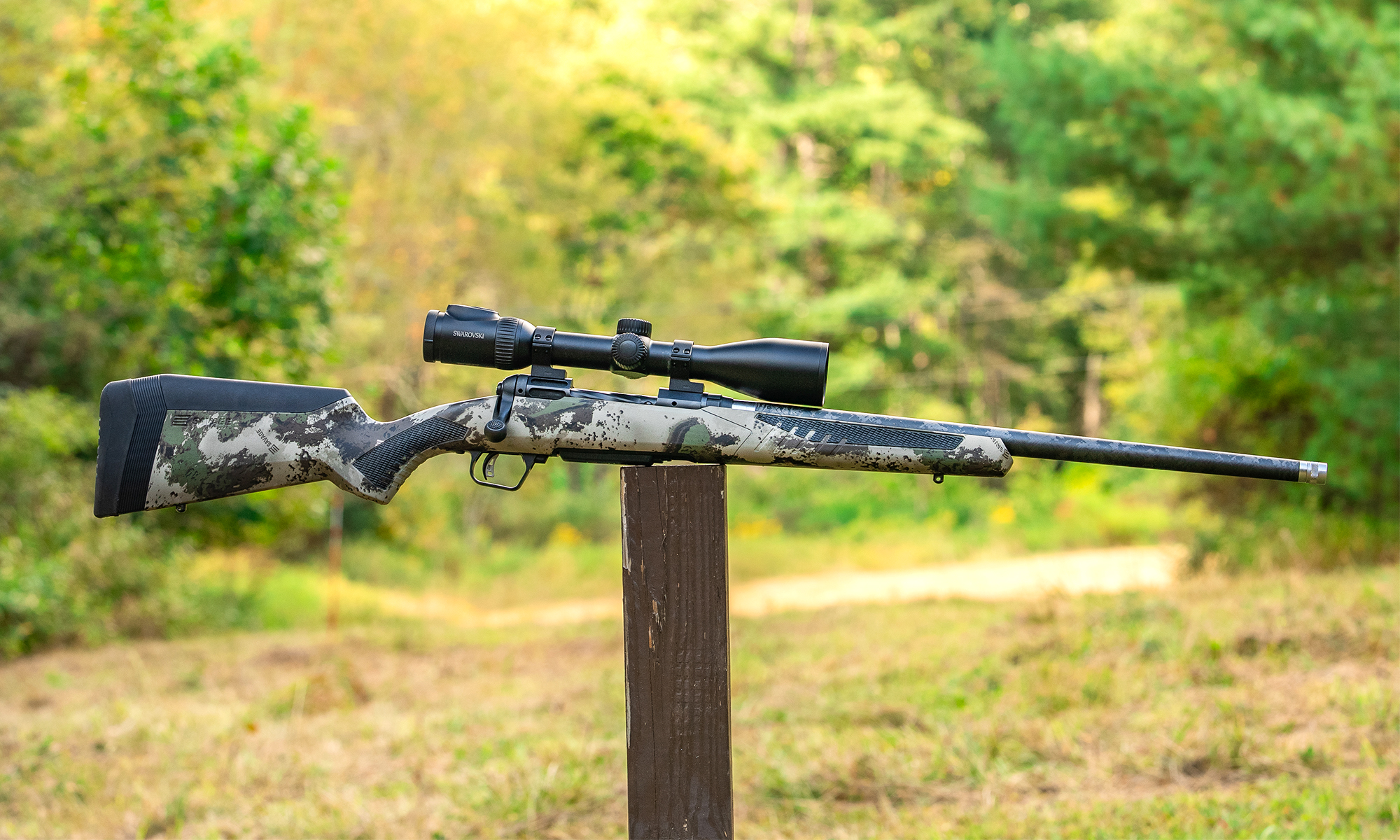 The new Savage 110 Ultralite Camo bolt-action rifle balanced on a post in a field. 