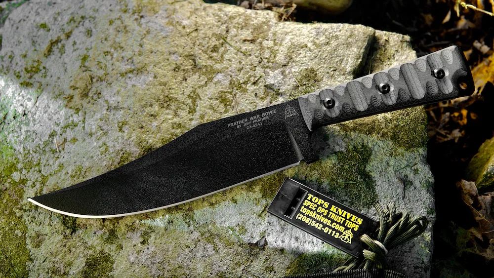 Tops Prather War Bowie Knife lying on rock