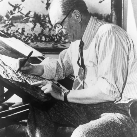 Conservationist Ding Darling drawing at his desk