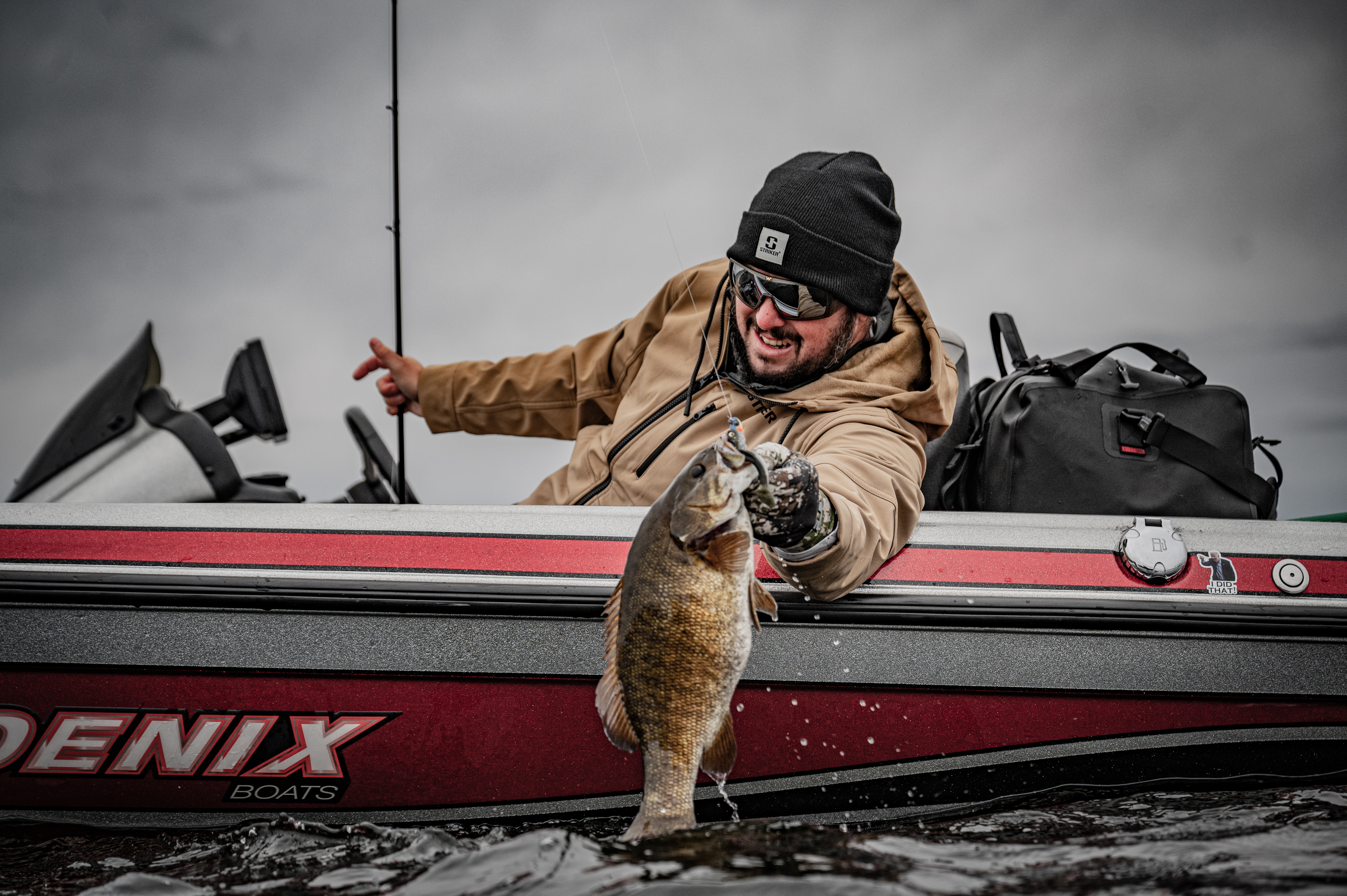 Angler holding bass next to boat