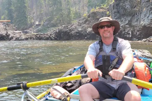 A fisheries biologist rows a raft on a whitewater river in Idaho. 