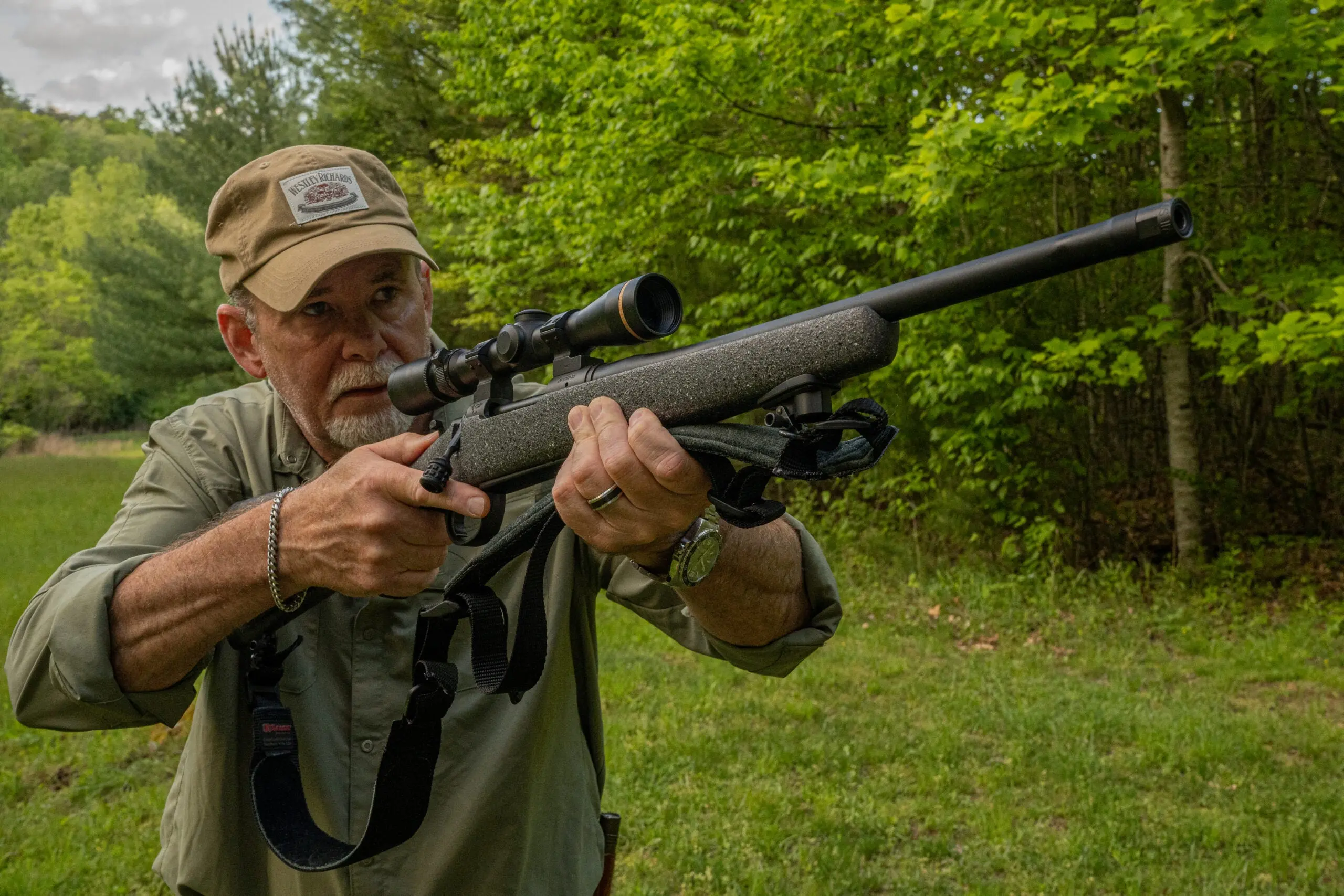 A shooter practices properly mounting a rifle on a backyard range. 