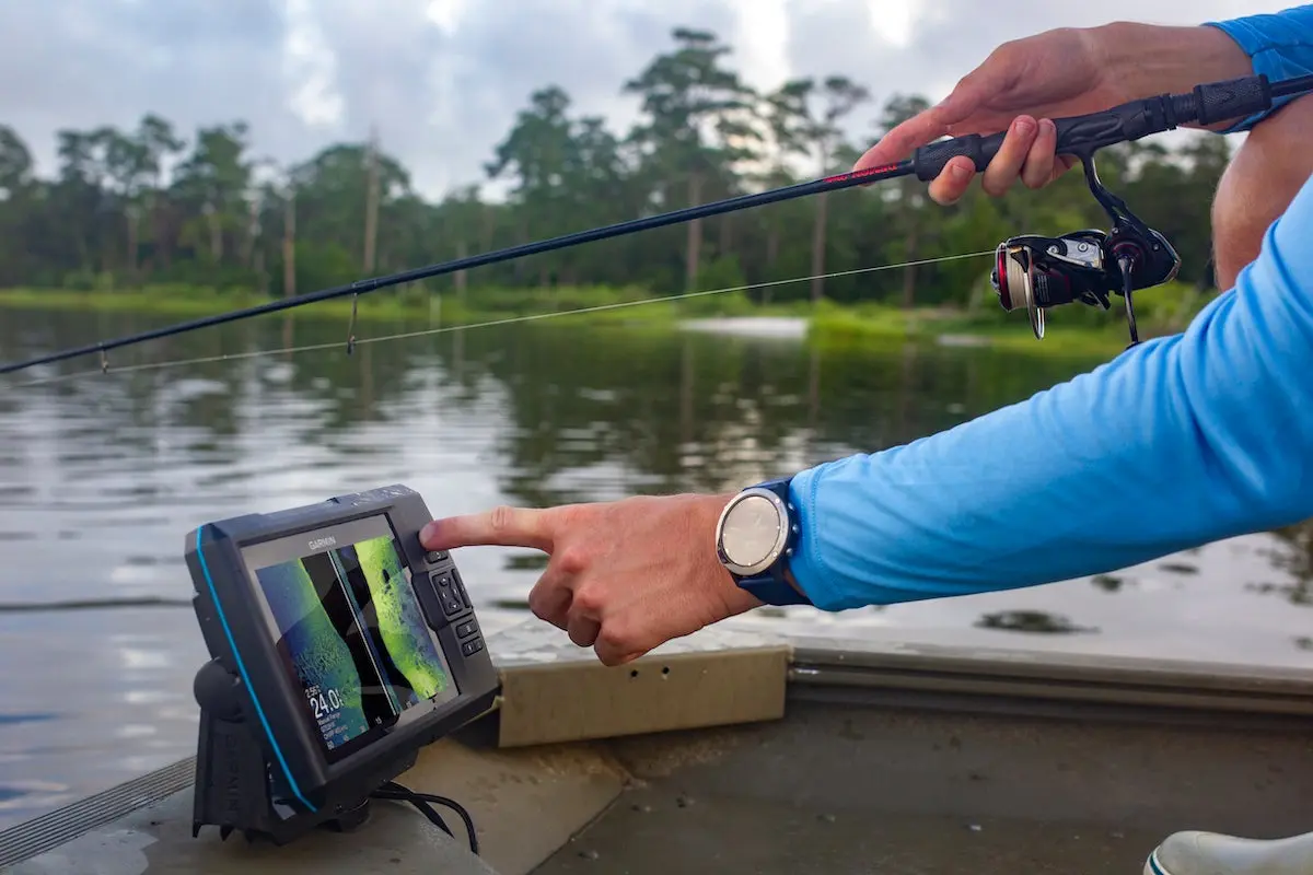 Angler using Garmin Striker Vivid 7sv fish finder on boat