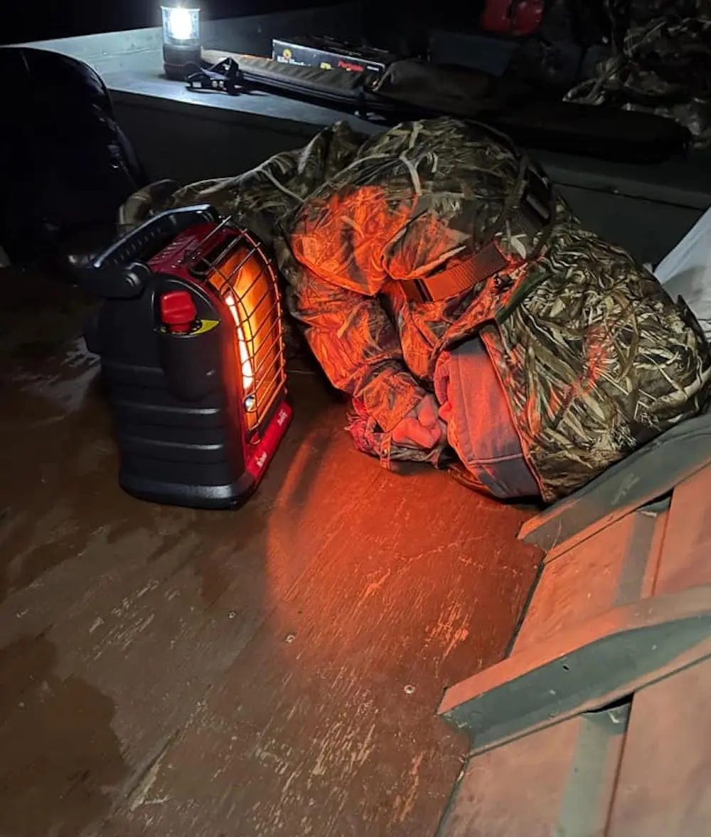 Female hunter using Mr. Heater Buddy portable propane heater on jon boat