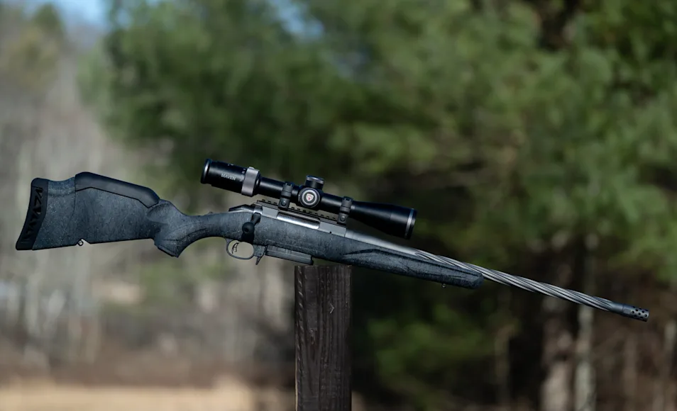 The new Ruger American Gen II rifle resting on a post with woods in background