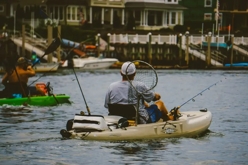 Two kayak anglers make their way down a river.