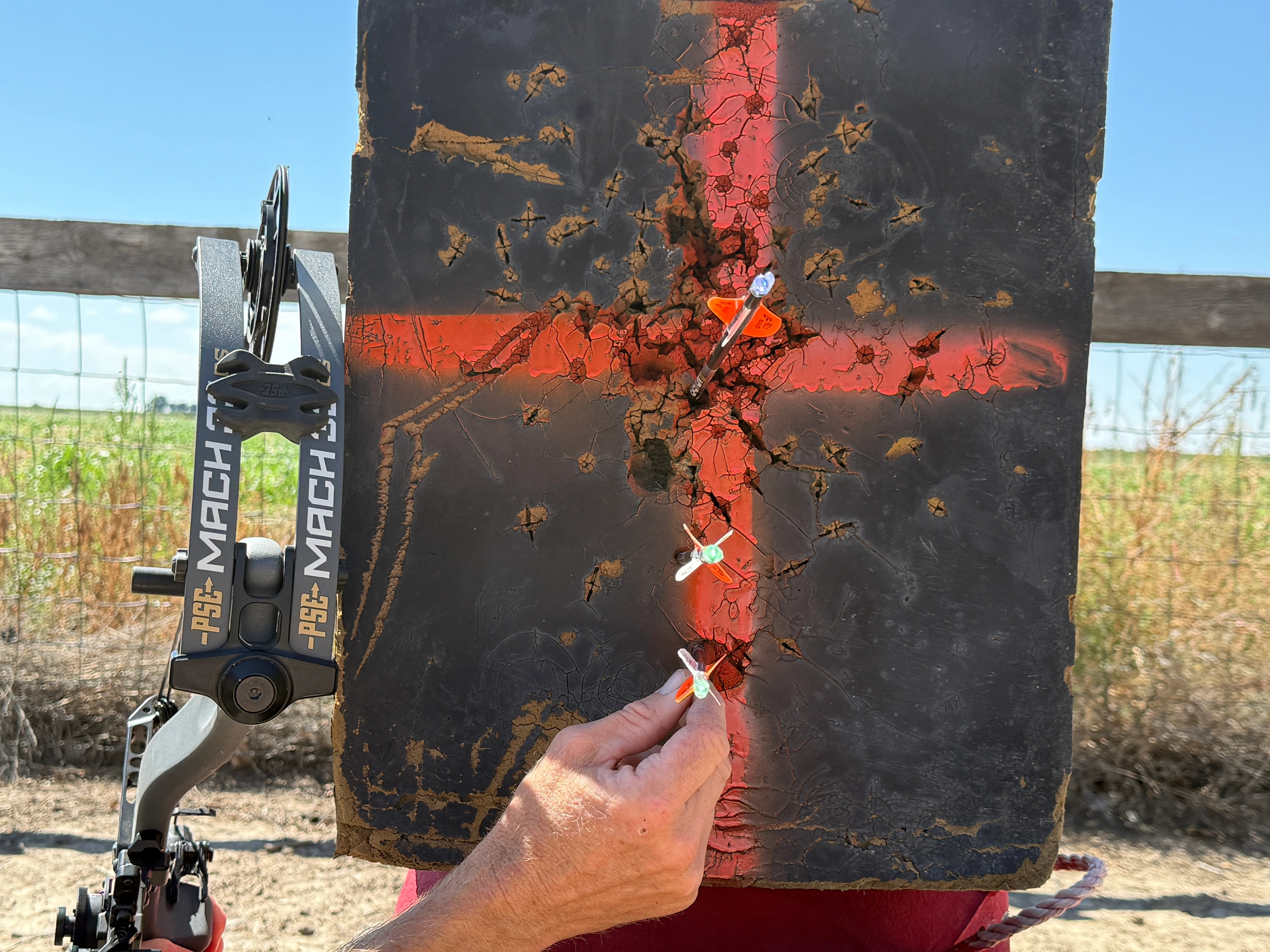 Three arrows lined up along a vertical axis on a bow target for walk back tuning. 