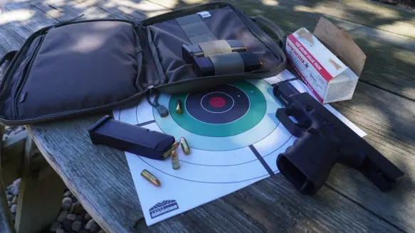 glock next to targets and pistol case