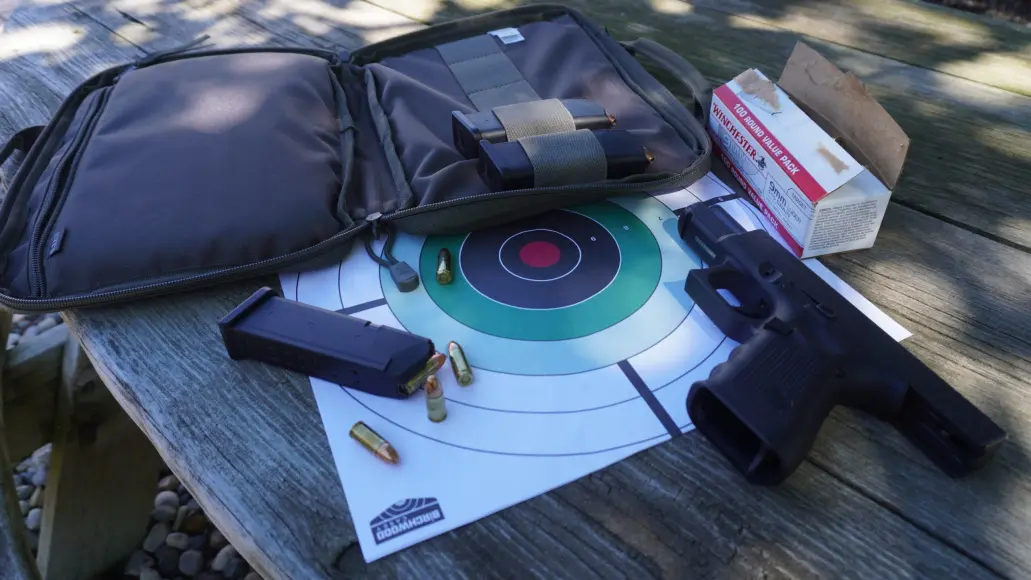 glock next to targets and pistol case