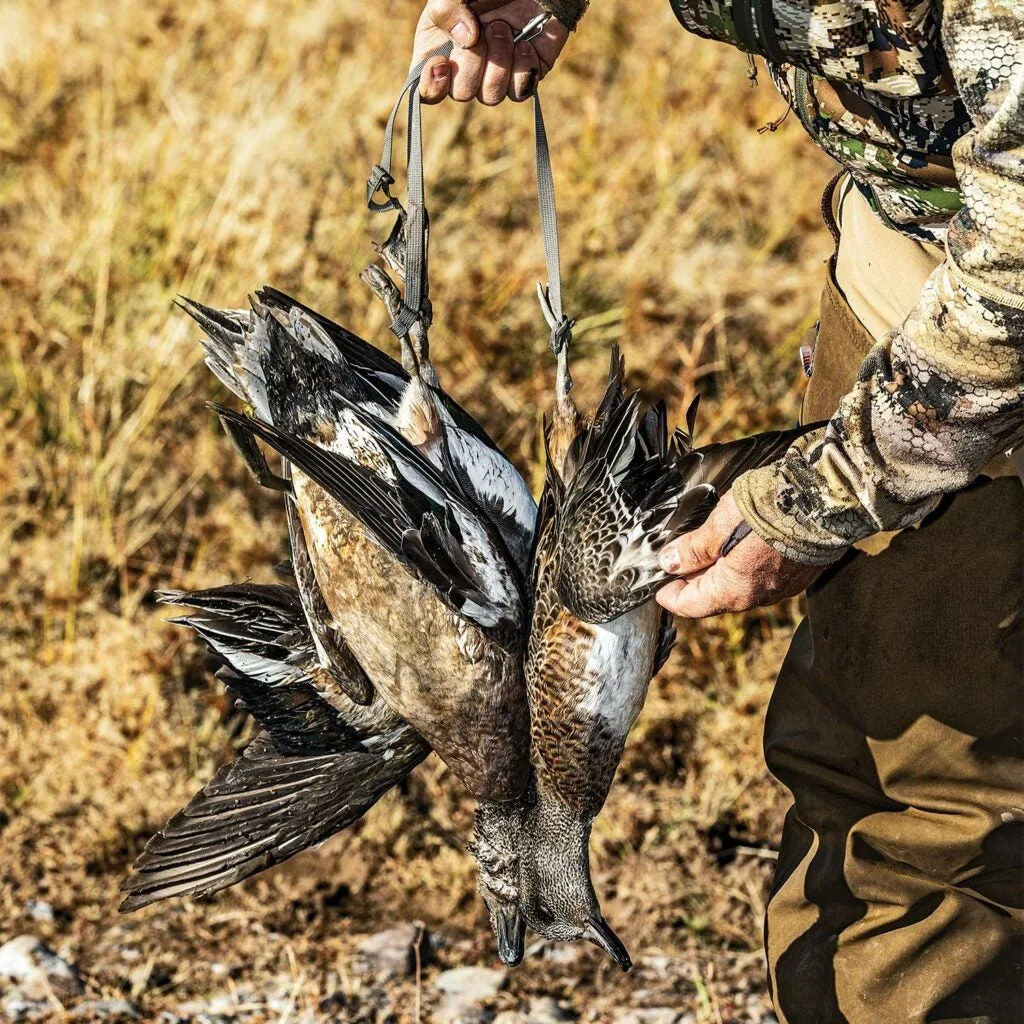 Hunter holding up a few ducks.