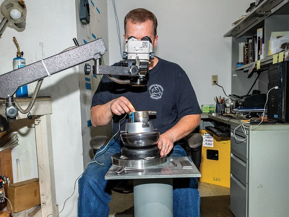 man using an engraver on a gun