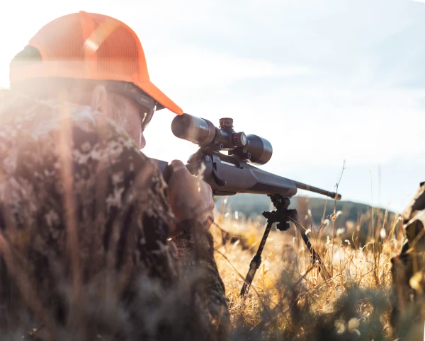 Hunter looking through scope in the field