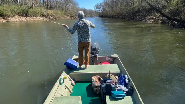 fisherman stands on small boat