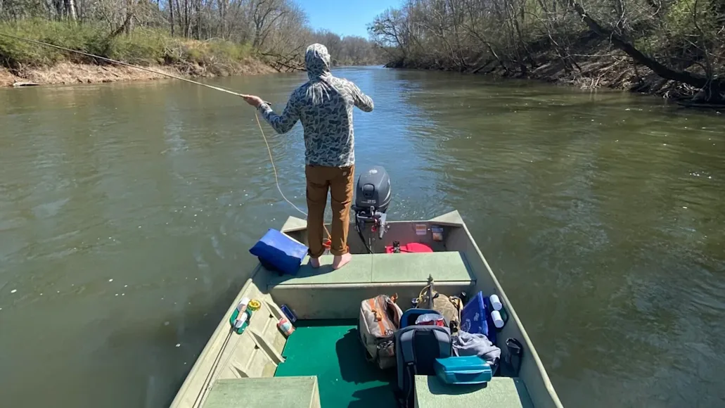 fisherman stands on small boat