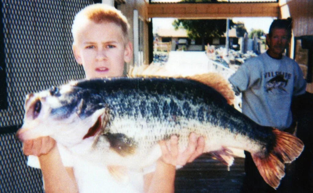 A boy holding a fish. 