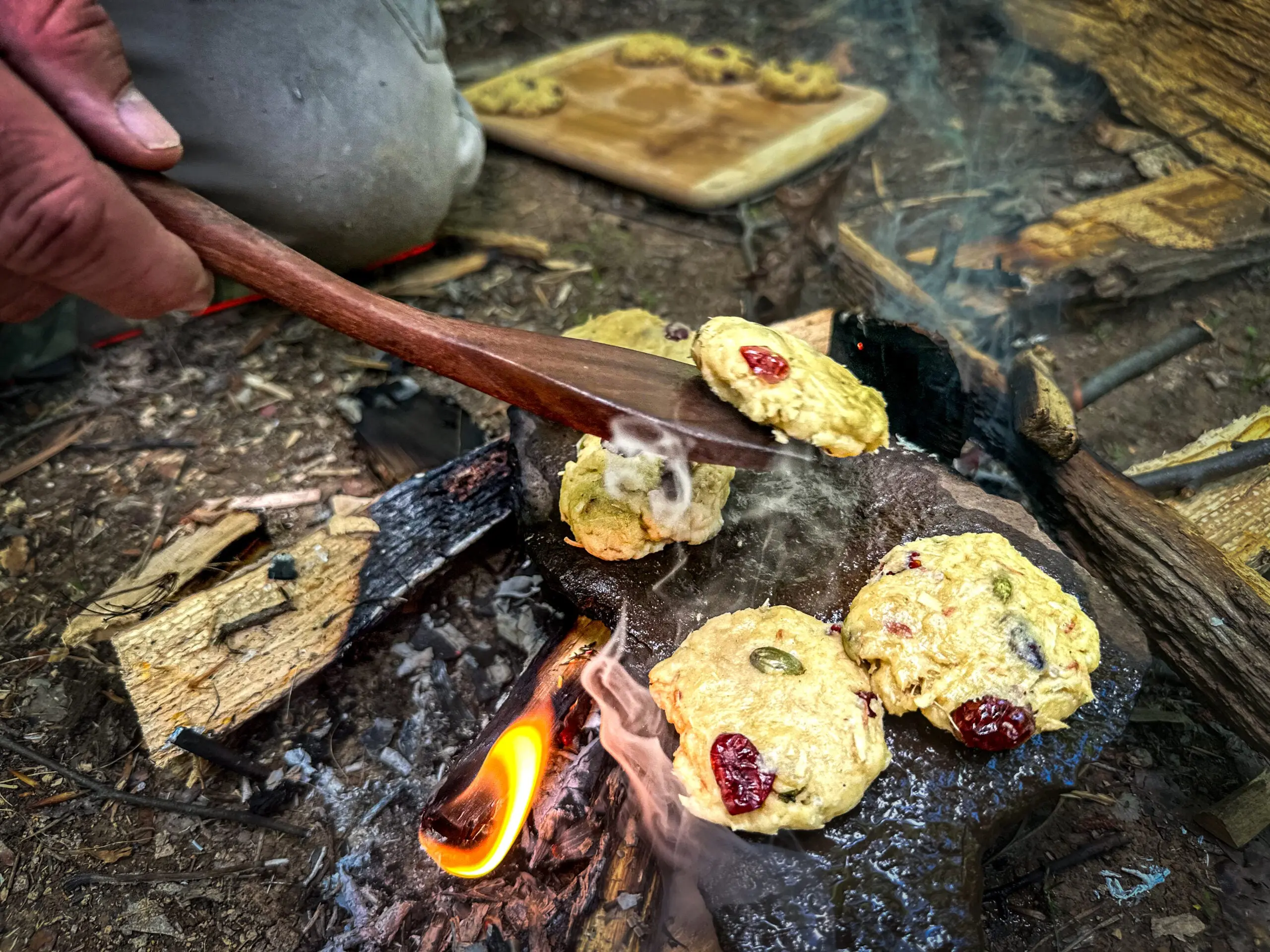 Cooking pine bark cookies on a rock