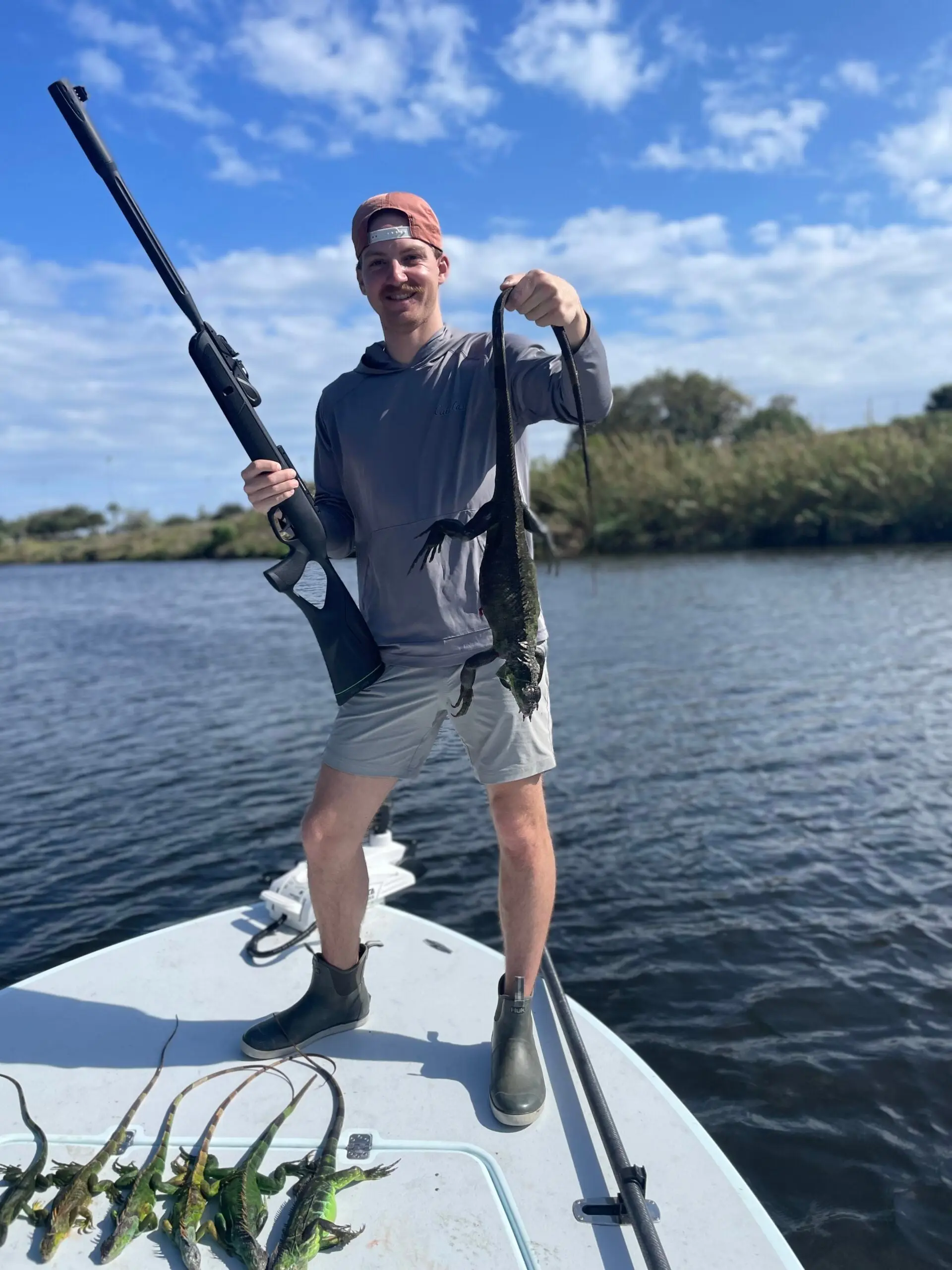 hunter holds up iguana while florida iguana hunting