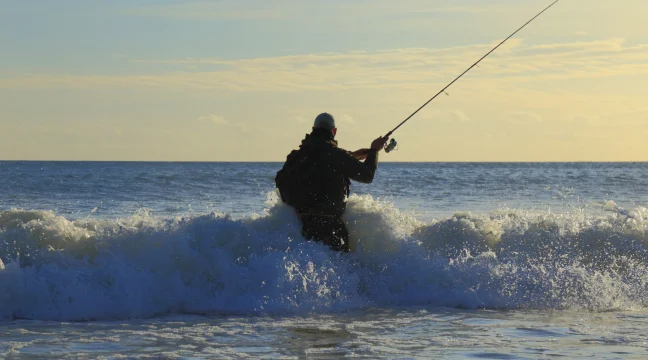 Surf fisherman standing in the waves while making a cast