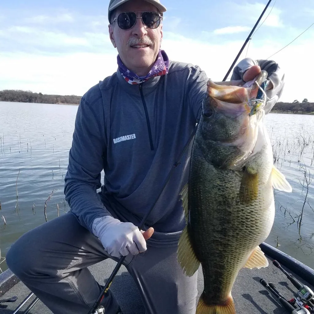 Angler holding up a largemouth bass.