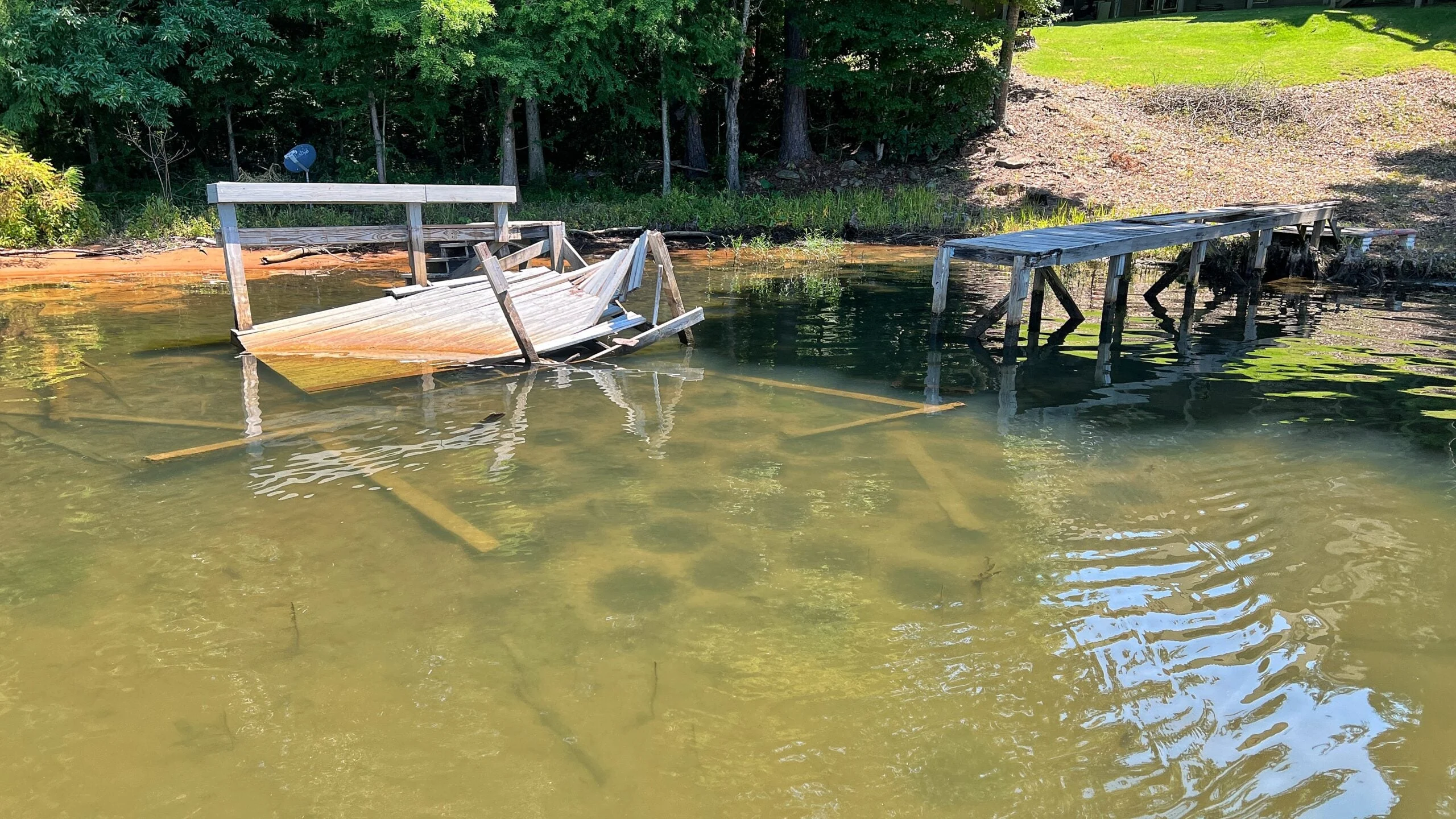 Bluegill spawning beds appear as dark circles under a broken down boat dock.