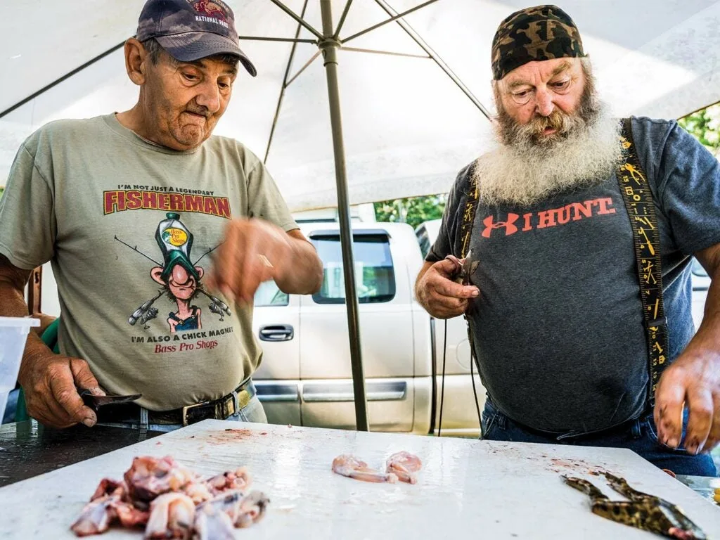 two men butchering frogs