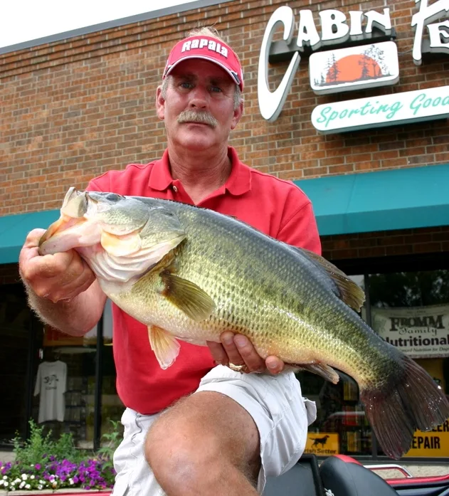 An angler poses with the Minnesota state record largemouth bass. 