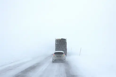 Car driving on a snowy road with the best snow tires.