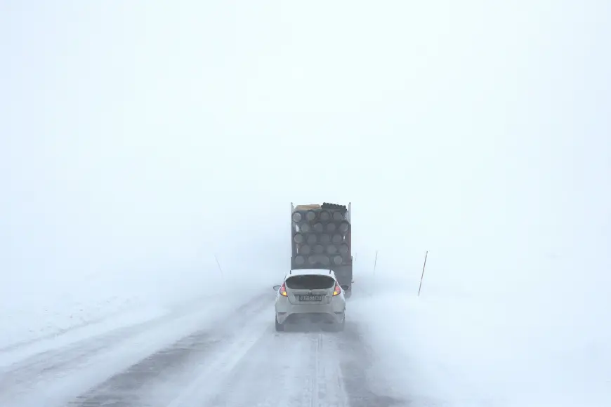 Car driving on a snowy road with the best snow tires.