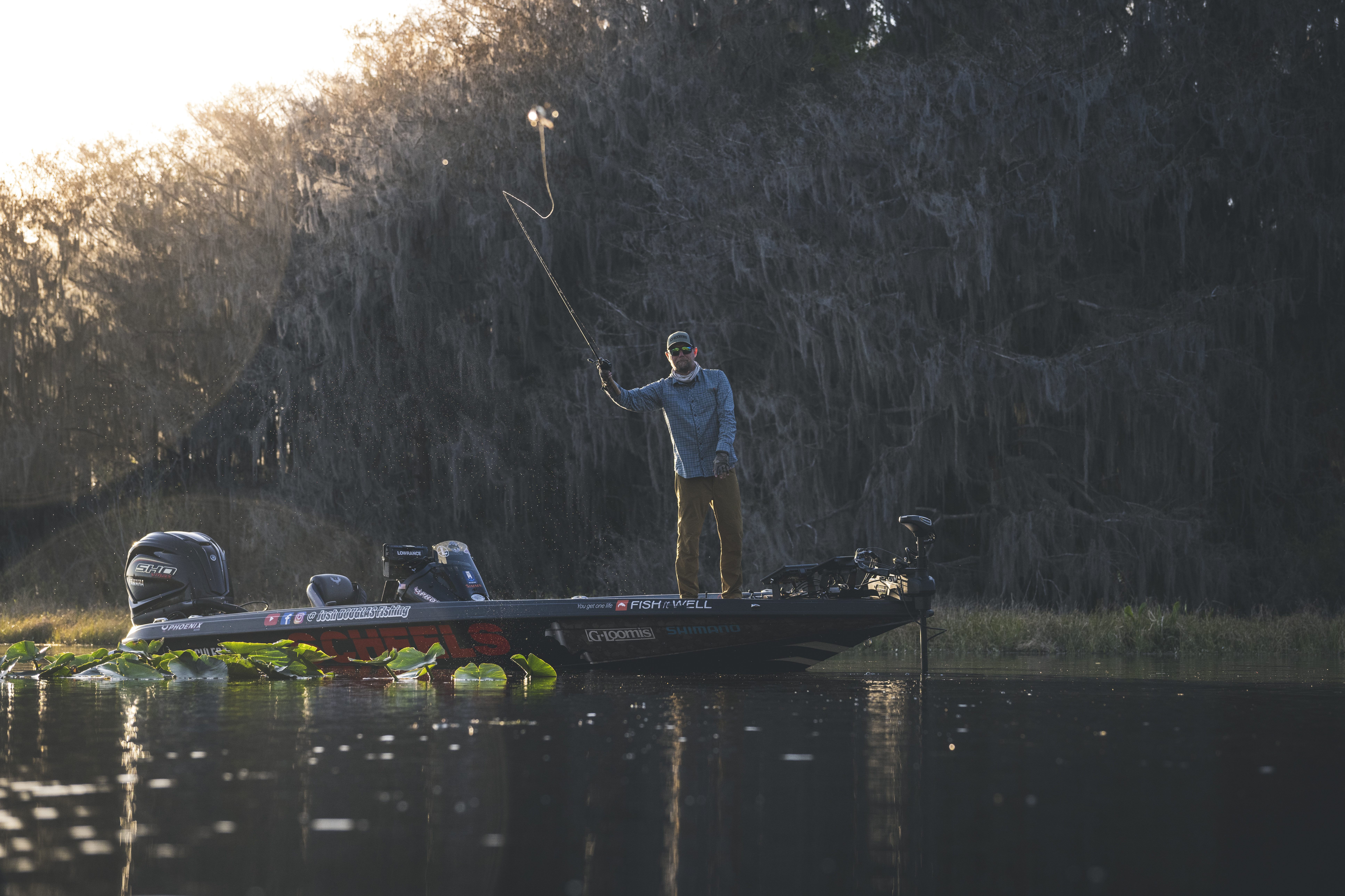 Angler casting a lure from the bow of a bass boat