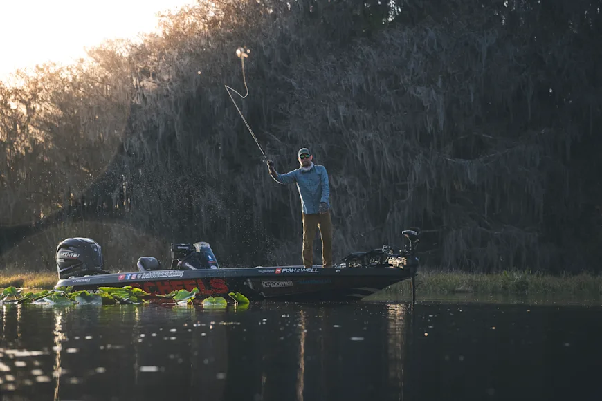 Angler casting a lure from the bow of a bass boat