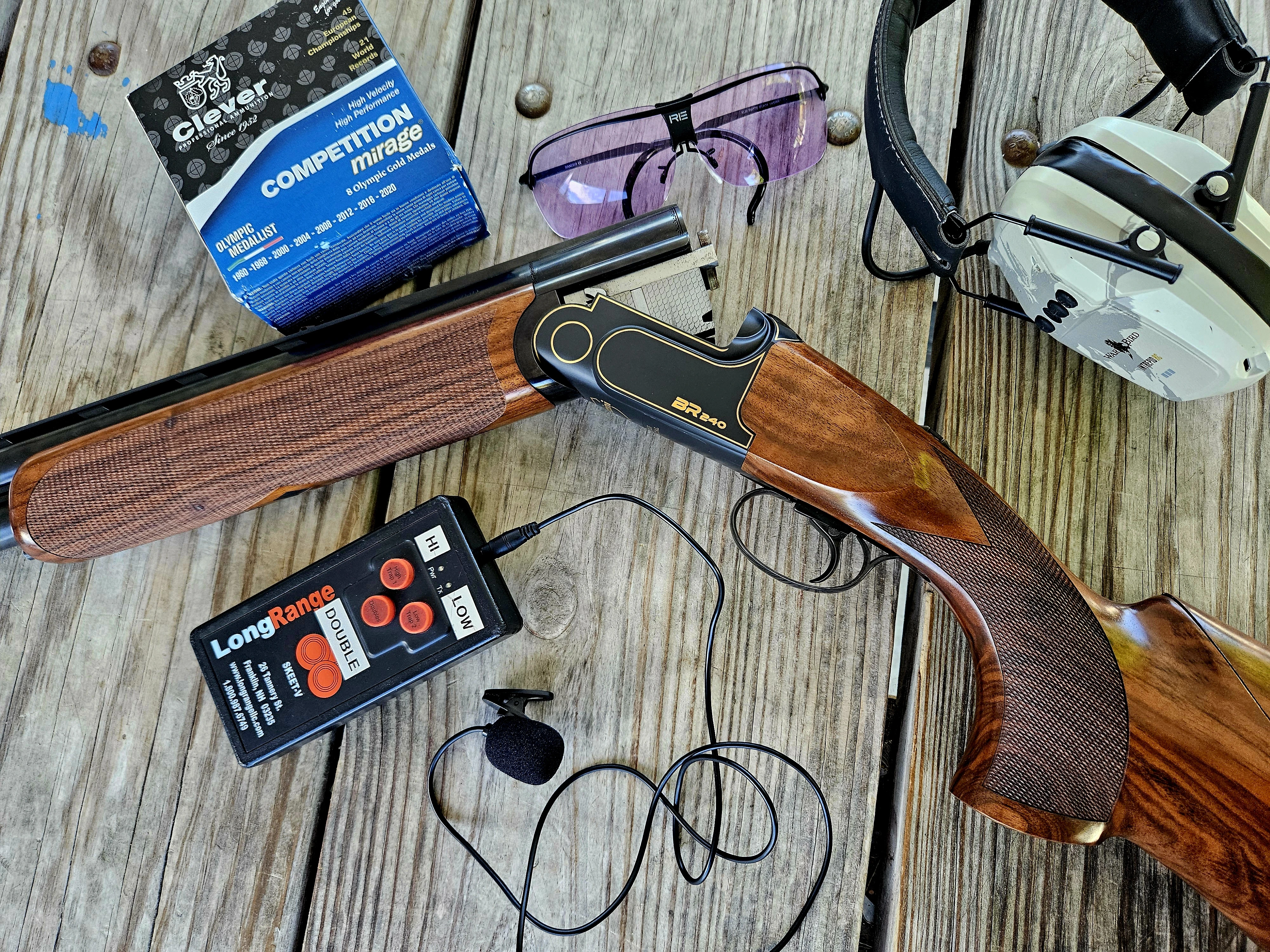 The new Rizzini Cole Special BR 240 on a wood surface with hearing protection, shooting glasses, and a box of shells. 