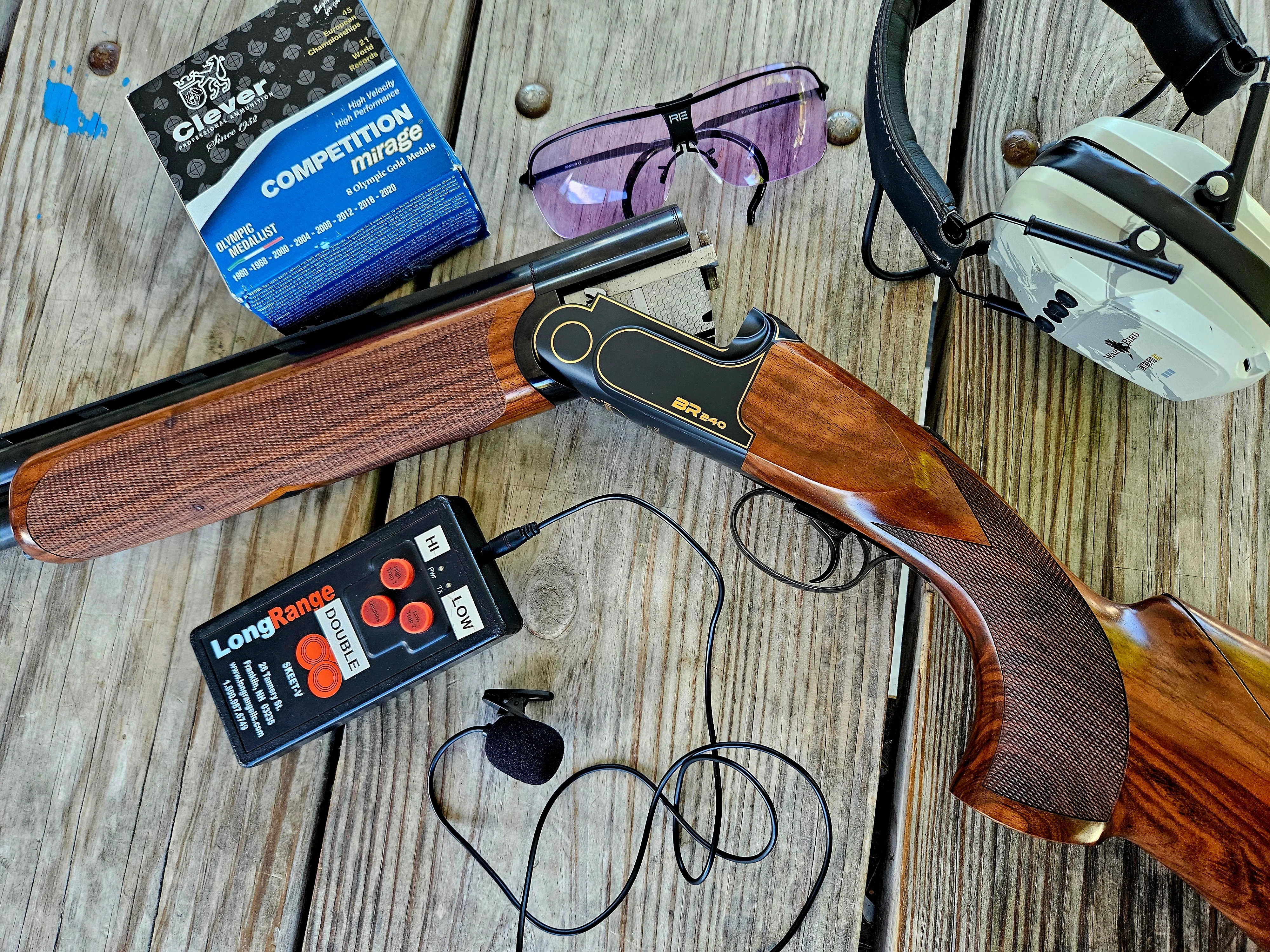 The new Rizzini Cole Special BR 240 on a wood surface with hearing protection, shooting glasses, and a box of shells. 