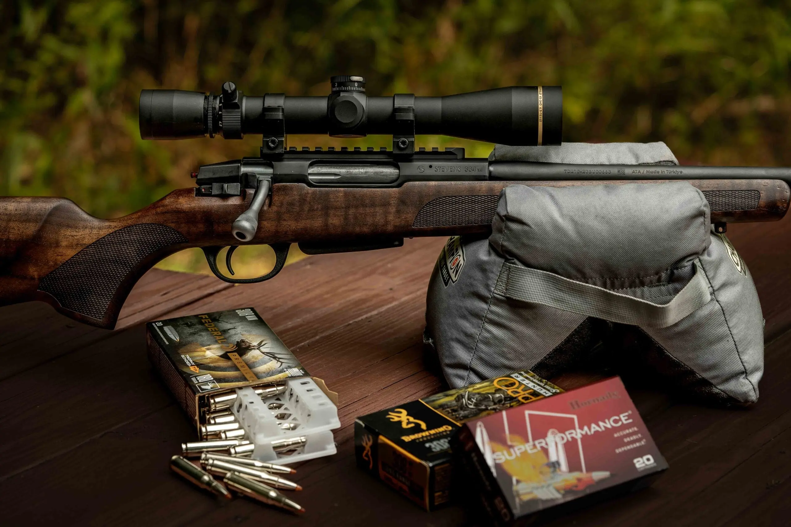 close-up of rifle on sandbag with boxes of ammo in front