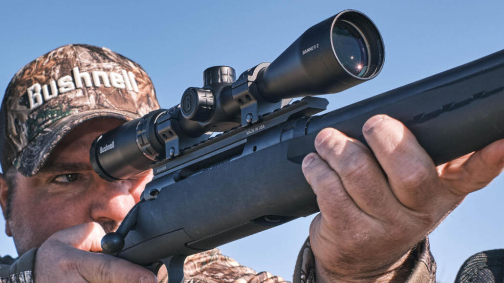 Hunter looking through Bushnell Banner rifle scope mounted on gun