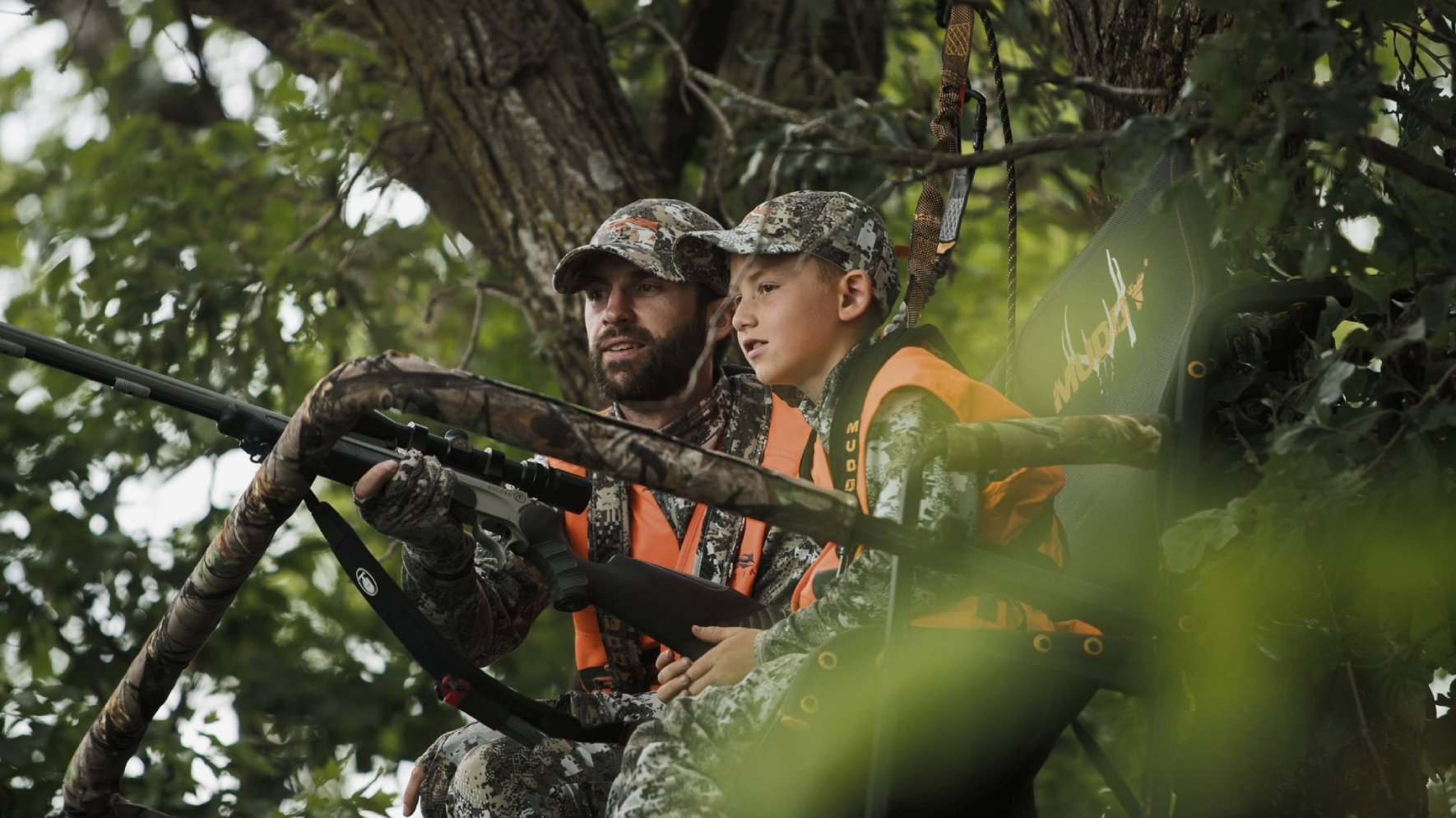 Father and son hunting in Muddy Treestand