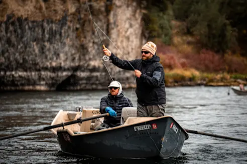 Fisherman making a cast on a drift boat