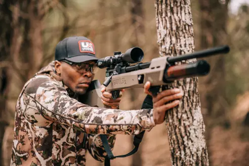 Hunter aiming a PCP air rifle.