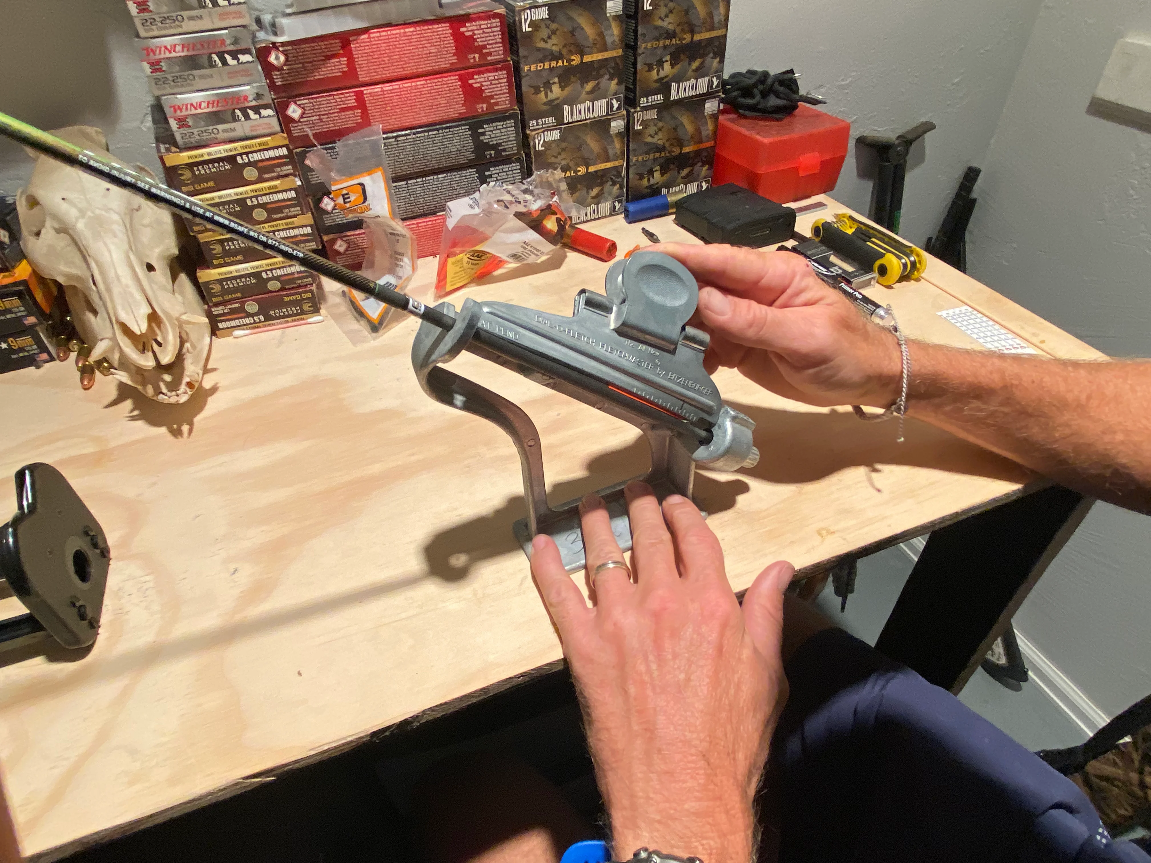 A person fletches a hunting arrow with a jig. 