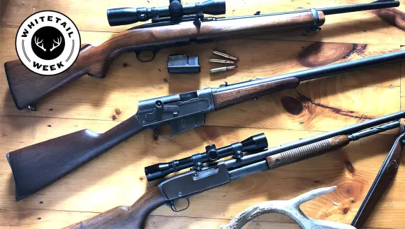 Three classic deer rifles on a table with ammo and an antler.