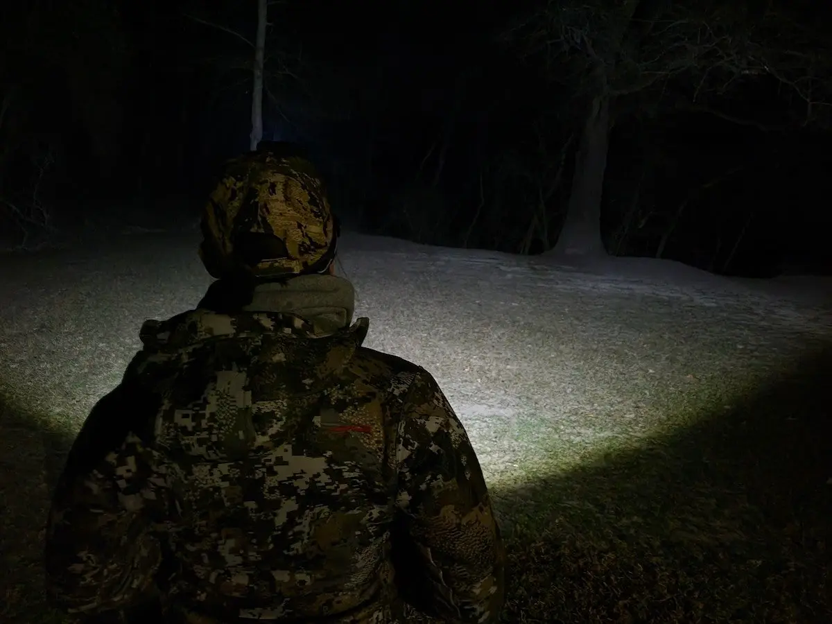 Female hunter wearing Ledlenser HF8R Signature headlamp at night