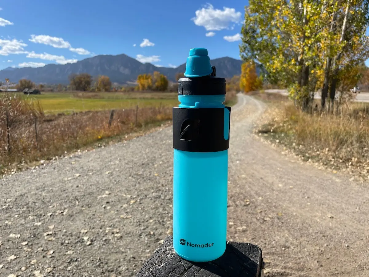 Nomader Collapsible Water Bottle sitting on dirt trail