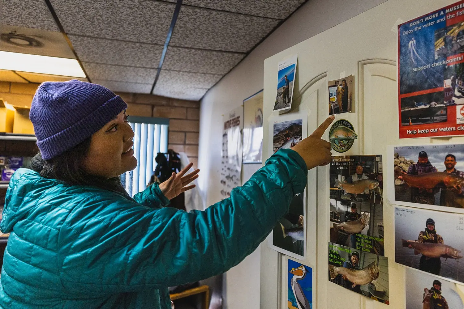 Woman points at photo on wall