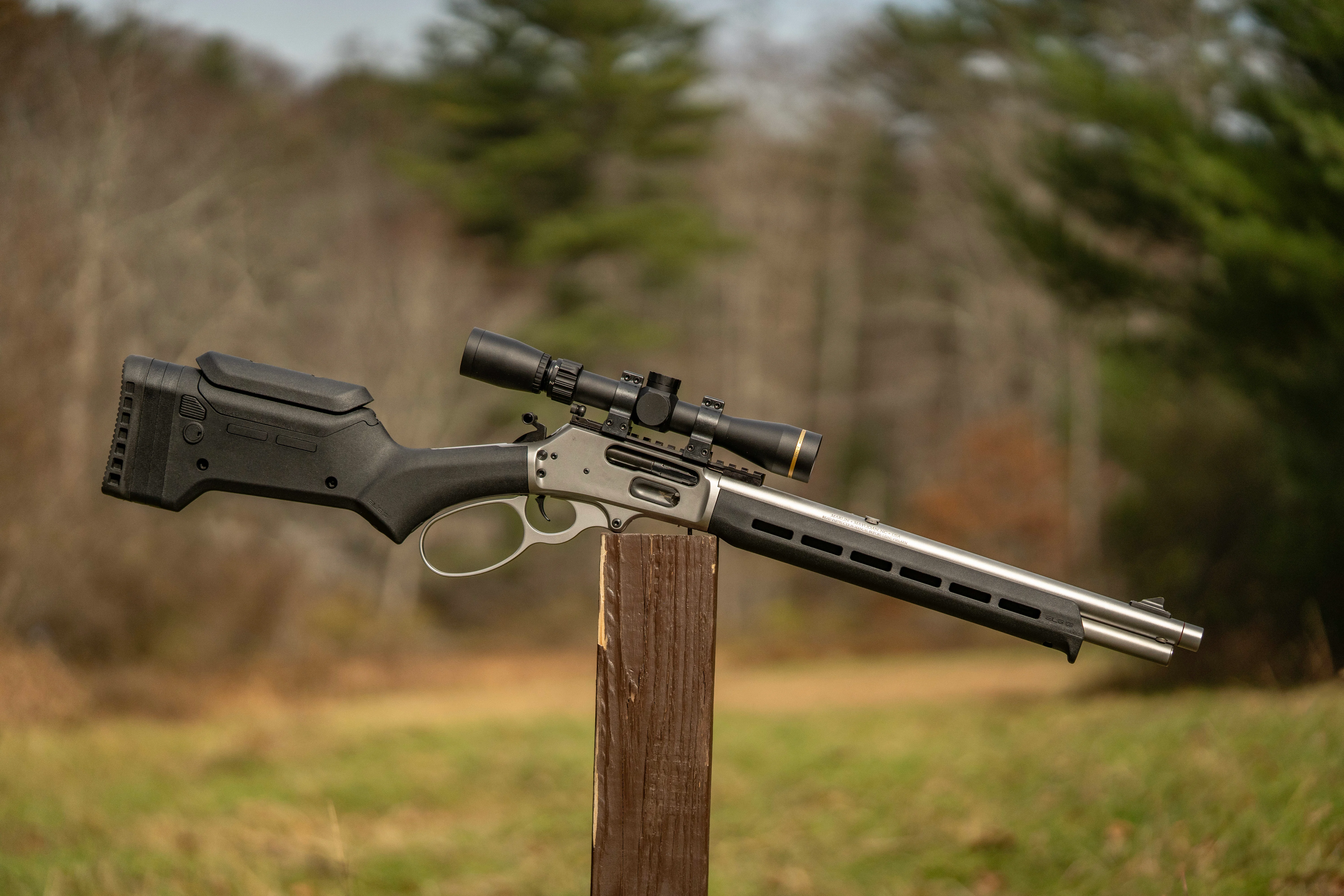 The new Marlin 1895 Trapper with Magpul stock balanced on a post with woods in background. 