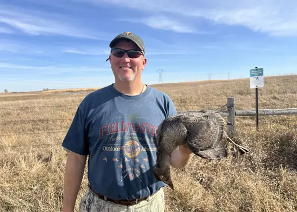 A hunter poses with a king eider taken in South Dakota. 