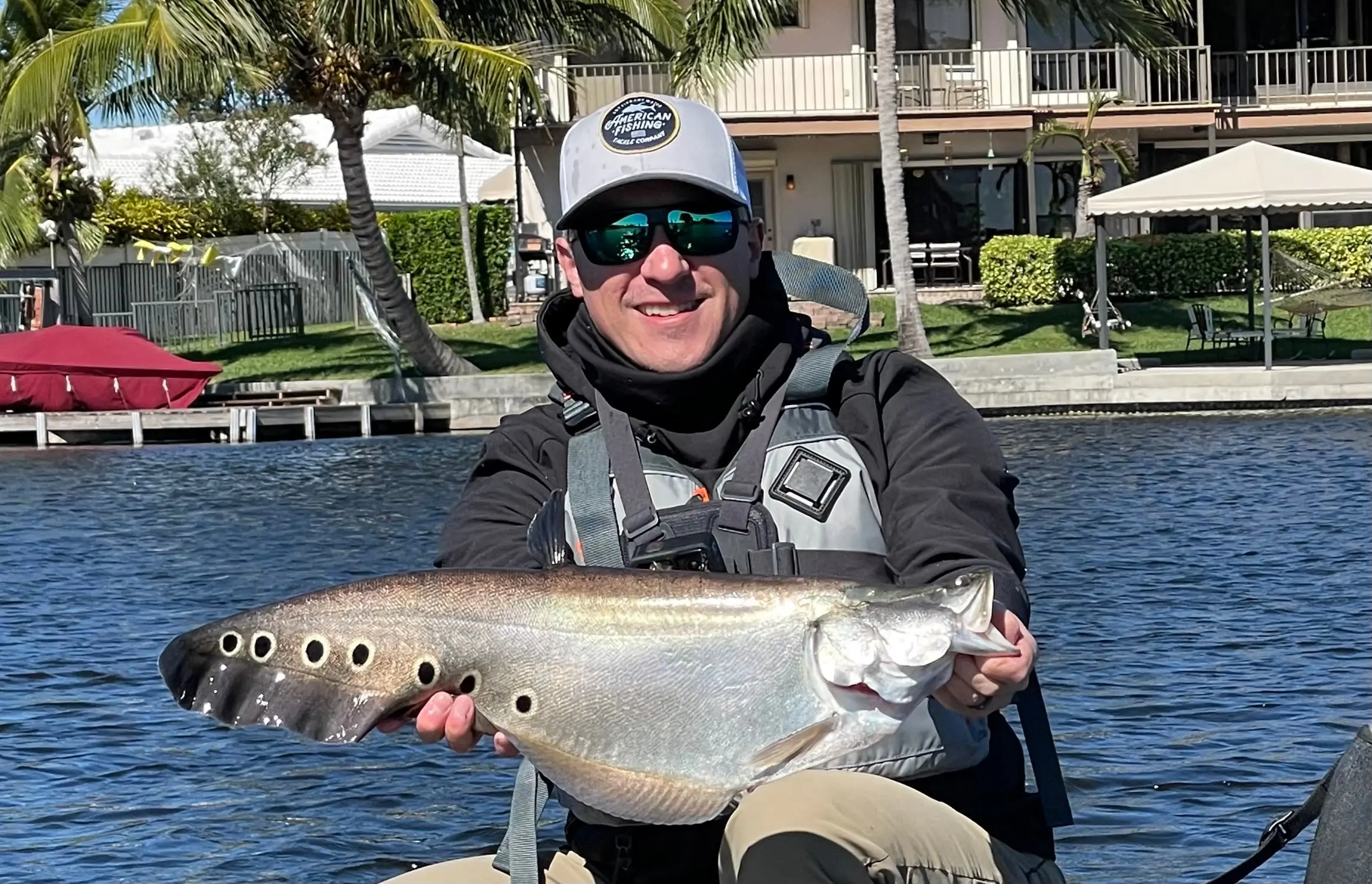 fisherman with a clown knifefish, an invasive species